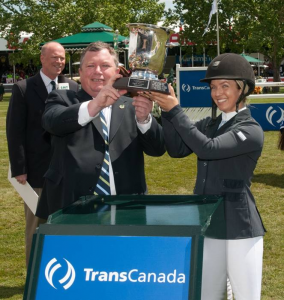 Ashlee Bond lifts her winning trophy with Karl Johannson, Executive Vice President, Natural Gas Pipelines, TransCanada. Photo © Spruce Meadows Media Services.  