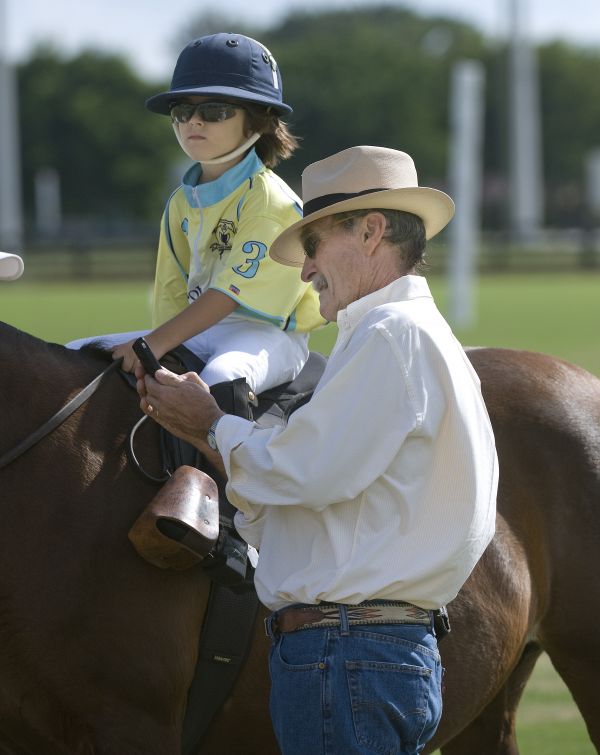 Six-year-old Finn Secunda of Polo School Yellow (3) waits patiently while his grandfather, British polo great and former 9-goaler Julian Hipwood takes a photo. Photo by Scott Fisher
