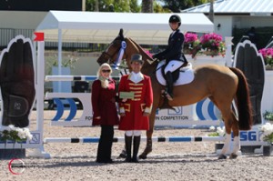 Adrienne Sternlicht, mounted on Oreade des Dames, is presented with a $1,000 bonus from SSG Gloves “Go Clean for the Green” promotion manager Jennifer Ward for wearing SSG ‘Digitals’ on her way to victory in the $15,000 High Amateur-Owner Classic held January 18 at the 2014 FTI Consulting Winter Equestrian Festival in Wellington, FL. Photo by Sportfot