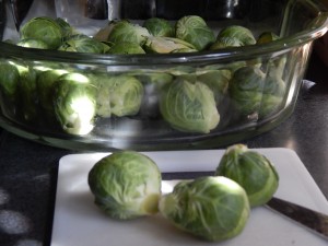 Trimming the bottoms of the Brussels sprouts, preparing them for baking.