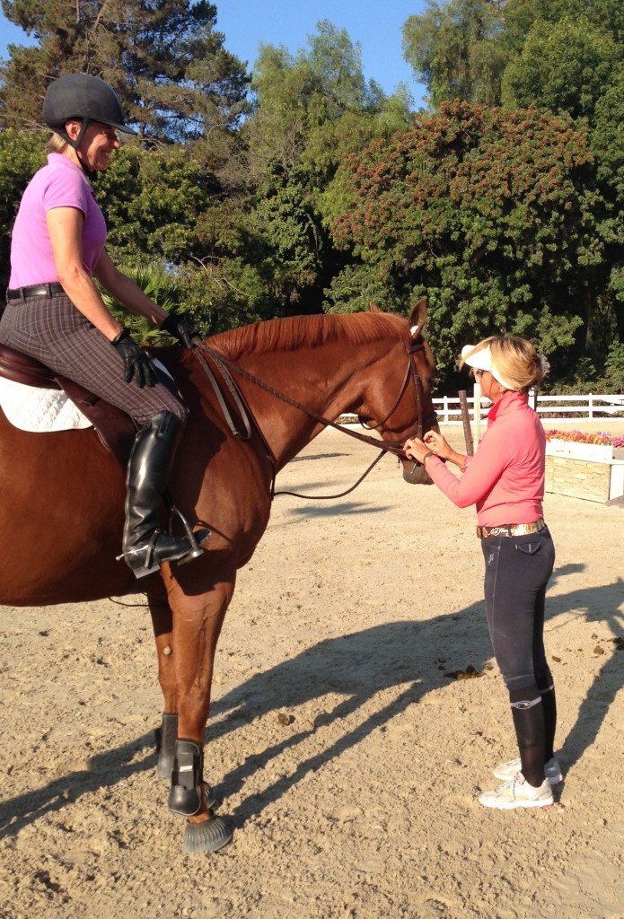 Devon back in action at Miraleste LLC at Sea Horse Riding Club, doing what she loves best, next to riding, of course – teaching. Shown here: adjusting Greg’s bridle for Linda Swanson. Photo courtesy of Carrie Silvano 