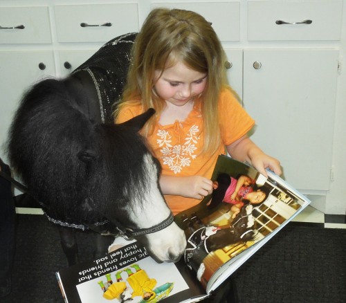 Therapy horse Magic reads with Taylor Kimmel, a survivor of Briarwood Elementary School in Moore, Oklahoma. Taylor's father, Toby Kimmel, was driving to the school to pick up his first grader when he saw the tornado destroy the school. Just hours after this photo was taken Taylor was in a storm shelter and became a two-time tornado survivor.
