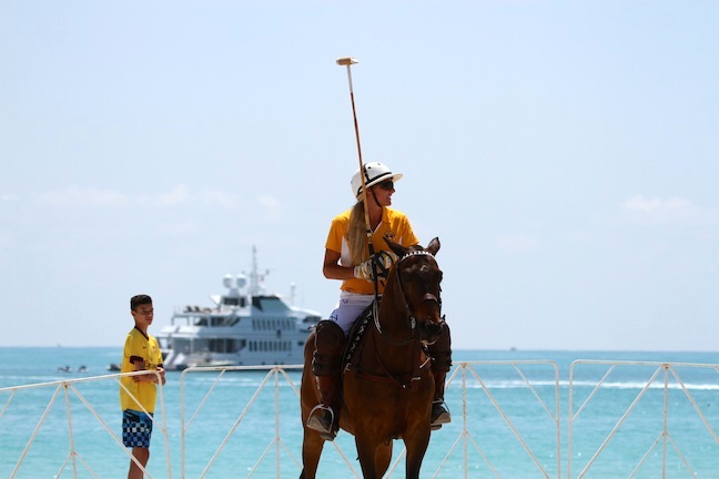 Kerstie playing beach polo while a yacht is anchored nearby. (Photo by Sheryel Aschfort, The Polo Papparazzi)
