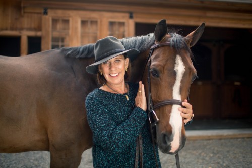 Gretchen Hunt, with Zoomerang, in a black and turquoise twisted cashmere crewneck sweater by Vince and a charcoal grey fedora hat by Tracy Watts at Findlay’s Ridge at SweetWater Farm in North Salem, New York. Photo by Brittnay Brett 
