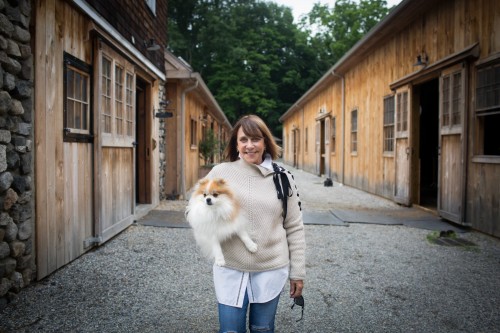 Gretchen Hunt, owner of Hunt Ltd., with Pomeranian, Nugget, in a Veronica Beard side lace crew neck sweater, lace trim Vince cotton shirt and AG Jeans at Findlay’s Ridge at SweetWater Farm in North Salem, New York. Photo by Brittnay Brett