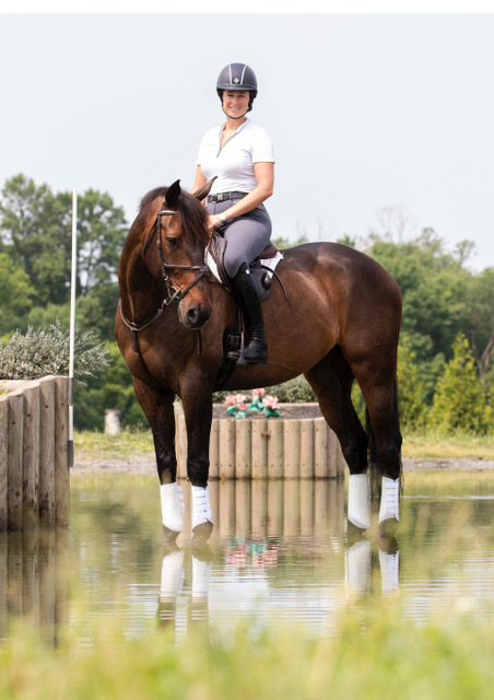 Lillian Heard and LLC Barnaby standing in the water on cross-country.